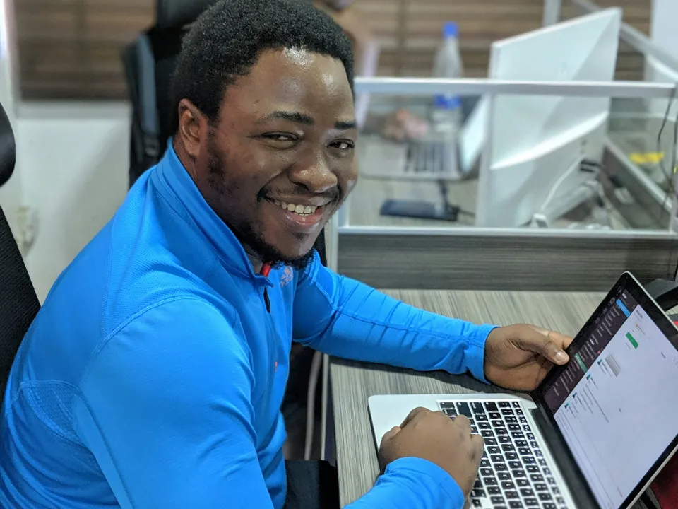 Persona sonriendo mientras aplica lo aprendido en su laptop