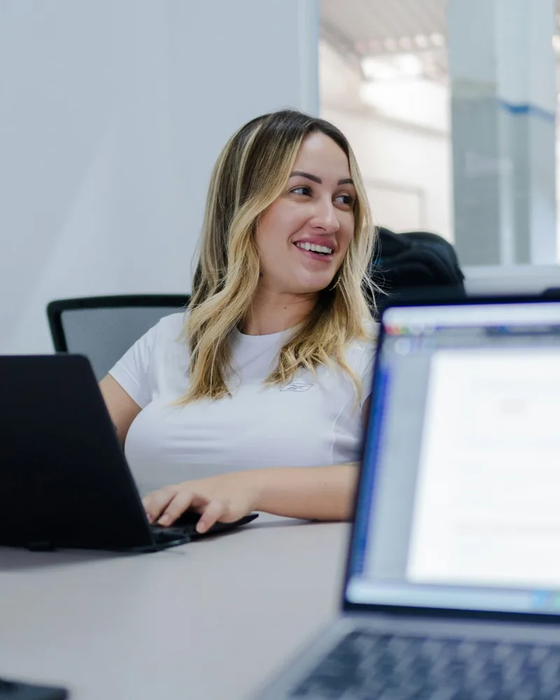 Profesional sonriendo frente a su laptop en una oficina